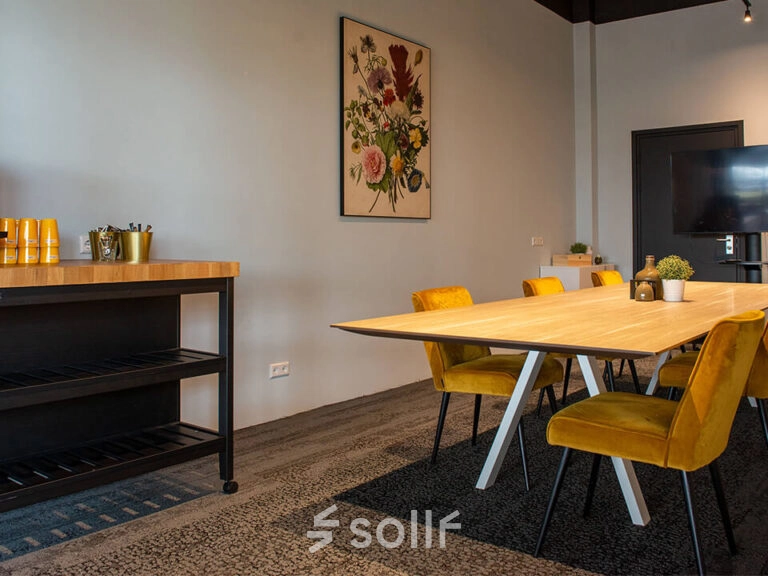 Modern ingerichte werkruimte in het kantoorpand op Zwartewaterallee 48, Zwolle met houten tafel en gele stoelen. Perfect voor kantoorruimte huren.