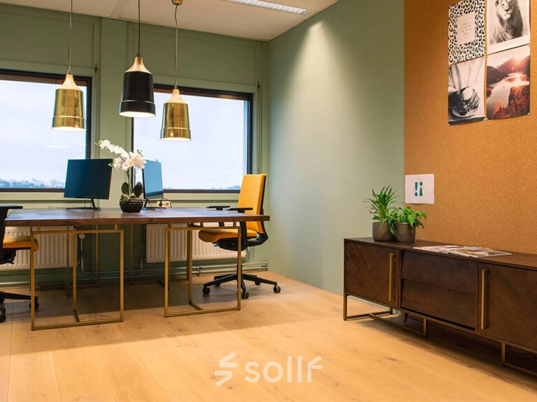 Moderne kantoorruimte met houten vloer en kleurrijke stoelen op Zwartewaterallee 48, Zwolle. Ideaal voor kantoorruimte huren, biedt het pand fijne werkplekken met planten en decoraties die een inspirerende werkomgeving creëren.