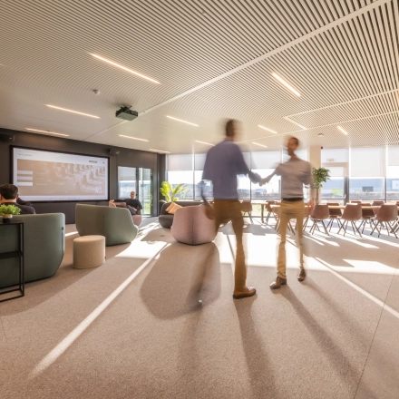 Moderne kantoorruimte te huur in Aalst met comfortabele zitplaatsen en zakelijke professionals die overleggen. Licht interieur en ruime opstelling aan de Korte Keppestraat 19 voor een inspirerende werkomgeving.