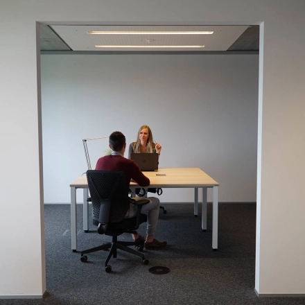Zakelijke bespreking in een moderne kantoorruimte te huur op Diamantstraat 8, Herentals, met twee personen aan een tafel.