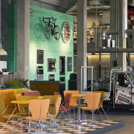 Kantoorruimte te huur met kleurrijke stoelen en bijzondere decoraties op de wand, ideaal voor creatieve werkruimtes. Gelegen op Diamantstraat 8 in Herentals, biedt het ruimte voor zakelijke bijeenkomsten.