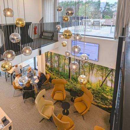 Moderne kantoorruimte te huur in Westerlo met stijlvolle zitgedeelte en hanglampen, ideaal voor informele vergaderingen. Kantoorruimte huren op Olenseweg 375 biedt een inspirerende werkomgeving.