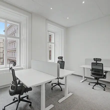 Helles Büro in Wollzeile 11, 1010 Wien mit großen Fenstern, zwei Schreibtischen und ergonomischen Stühlen. Ideal zum Büroraum mieten im Herzen der Inneren Stadt.