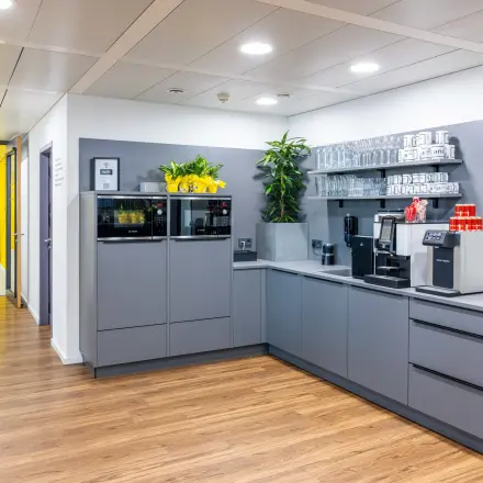 Moderner Büroraum mit stilvoller Küche und Pflanzen in der Schönbrunner Straße 230, 1120 Wien. Perfekt für alle, die ein Büro mieten oder eine Bürofläche mieten möchten.