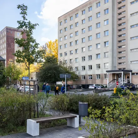 Außenansicht eines Bürogebäudes in Berlin Friedrichshain mit umliegendem Grün und geparkten Autos; ideal für Büro mieten.