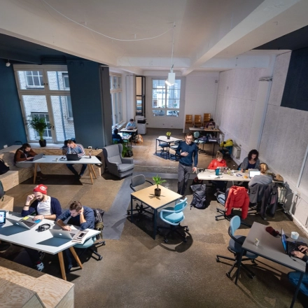 Modernes Büro in Berlin Kreuzberg, Rudi-Dutschke-Straße 23, zeigt verschiedene Bereiche mit Schreibtischen und Personen bei der Arbeit. Ideal für büroraum mieten mit flexibler Nutzung.