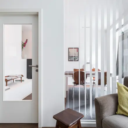 Moderner Büroraum in Berlin Mitte mit hellen Wänden, Glaselementen und gemütlichem Sitzbereich, ideal zum Büro mieten.
