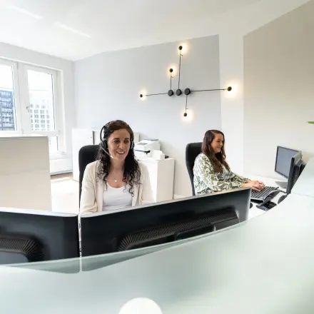 Helles Büro am Leipziger Platz 15, Berlin Mitte, mit stilvollen Büromöbeln und zwei arbeitenden Personen am Schreibtisch.