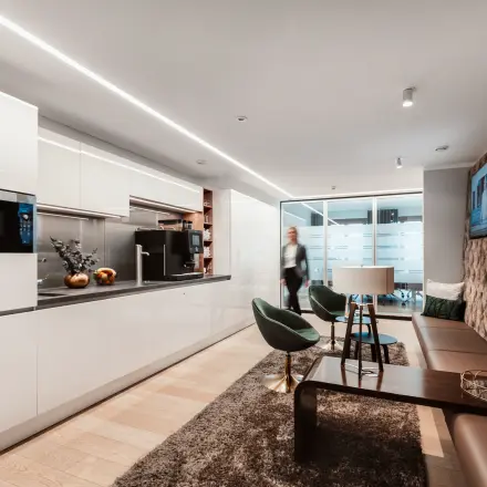 Modernes Büro in Berlin Mitte am Pariser Platz 6a mit stilvollem Interieur, gemütlicher Sitzecke und eleganter Küche, ideal zum Büro mieten.