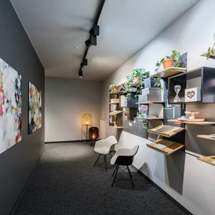 Ein stilvoller Büroraum in Berlin Mitte, Unter den Linden 26-30, mit kreativer Wanddekoration und zwei Stühlen für informelle Gespräche. Ideal für dynamische Teams, die Bürofläche mieten möchten.