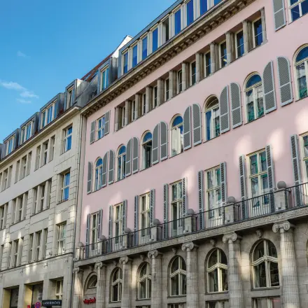 Die Fassade eines Bürogebäudes in Berlin Mitte, Unter den Linden 26-30, ideal für alle, die Bürofläche mieten möchten. Klassische Architektur mit hohen Fenstern.