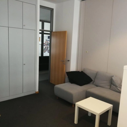 Kompakter Büroraum in Berlin Mitte, Zinnowitzer Straße 1, mit grauer Couch und kleinem Tisch, ideal zum Büro mieten.