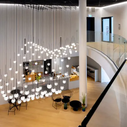 Moderne Bürofläche mieten in Frankfurt Bockenheim. Eleganter Eingangsbereich mit stilvoller Beleuchtung und einer kleinen Lounge.