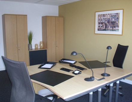 Modernes Büro mit zwei Schreibtischen, schwarzen Bürostühlen, Aktenordnern und Lampen, perfekt zum Büro mieten in Leipzig Engelsdorf.
