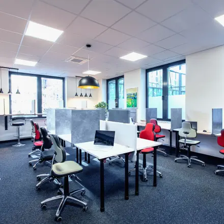 Helles Büro in München Laim mit modernen Schreibtischen und ergonomischen Stühlen, ideal für die Bürofläche mieten. Große Fenster bieten viel Tageslicht.