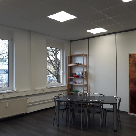 Helles Büro in München Pasing mit großen Fenstern, Tisch und Stühlen, ideal für flexibles Arbeiten. Perfekt, um Bürofläche oder Büroraum zu mieten.