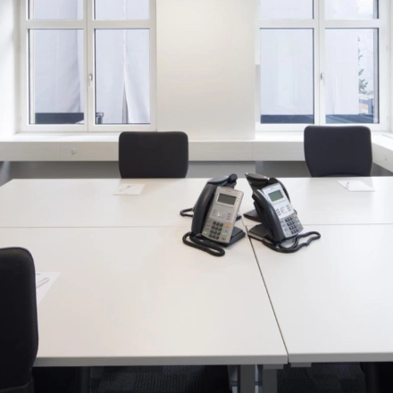 Helles Büro in der Bahnhofstrasse 52, Zürich City, mit sechs modernen Arbeitsplätzen, ideal zum Büro mieten. Große Fenster lassen viel Licht herein, während die Telefonanlagen bereitstehen.