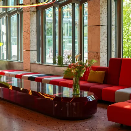 Modern eingerichteter Lounge-Bereich mit farbenfrohen Sitzgelegenheiten und großen Fenstern am Ernst Nobs Platz 1 in Zürich City. Ideal für Mieter, die eine Bürofläche oder Büroraum mieten möchten.