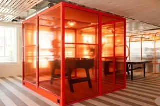 Modernes Büro mit rotem, verglasten Meetingraum und Tischfußball an der Stockerstrasse 33 in Zürich Enge.