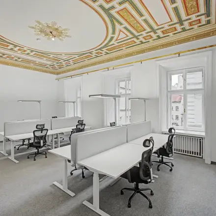 Bright, furnished office space with elegant ceiling design, featuring several workstations available for rent at Wollzeile 11, 1010 Vienna Center.