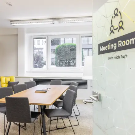 Bright office meeting room available for rent at Wohllebengasse 12/14 in 1040 Vienna. Features modern furnishings and large window providing natural light.