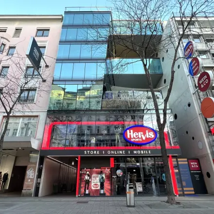 Exterior view of Mariahilfer straße 36, featuring a modern building with retail spaces and glass facade, ideal for office space rental in 1070 Vienna, Neubau.
