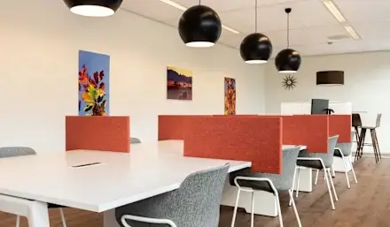 Spacious office to rent at Mariahilfer Straße 36, 1070 Vienna, featuring modern furnishings, vibrant artwork, and large windows providing natural light, ideal for workspace rental.