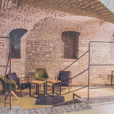 Cozy office space with exposed brick walls and modern seating at Zimmermanngasse 8, 1090 Vienna, suitable for rent office space.
