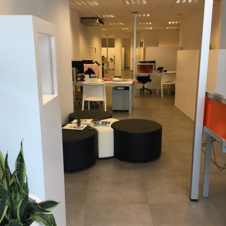 Interior view of office space at Keizersplein 24, Aalst België featuring desks and chairs suitable for office space rental. A few people are engaged in business activities.