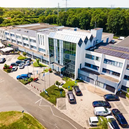 Exterior view of the office building at Bedrijvenpark Twente 305, Almelo, suitable for office space rental, with ample parking and surrounded by greenery.