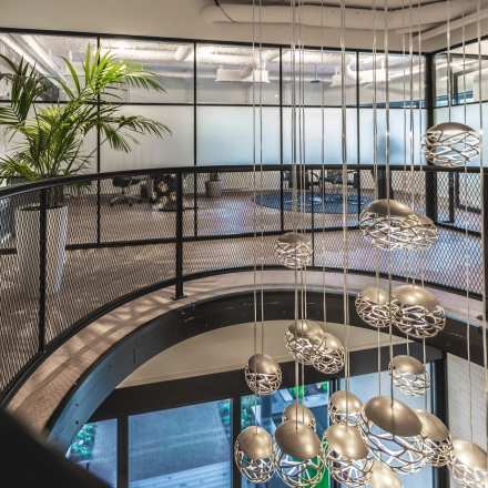 Modern office to rent featuring sleek glass walls, stylish lighting fixtures, and a contemporary open floor plan on Egbert Gorterstraat 2-14, Almelo.