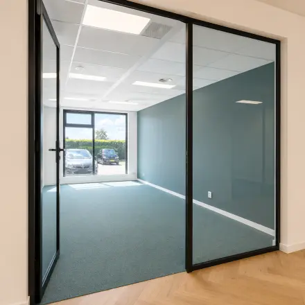 Spacious office to rent at Veluwezoom 15, Almere Stad, featuring a bright, unfurnished interior with large glass doors and ample natural light.