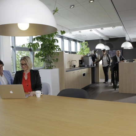 Modern office at Europalaan 16, Alphen aan den Rijn, featuring professionals discussing projects and a collaborative workspace ideal for office space rental.