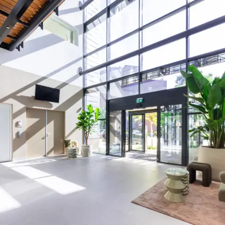 Bright, spacious entrance area with modern furnishings and large glass windows at Maanlander 43, Amersfoort Calveen, ideal for office space rental.