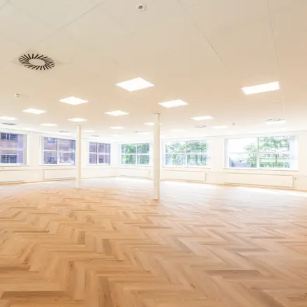 Bright office space with large windows and a wooden herringbone floor in Amersfoort Calveen for office space rental.