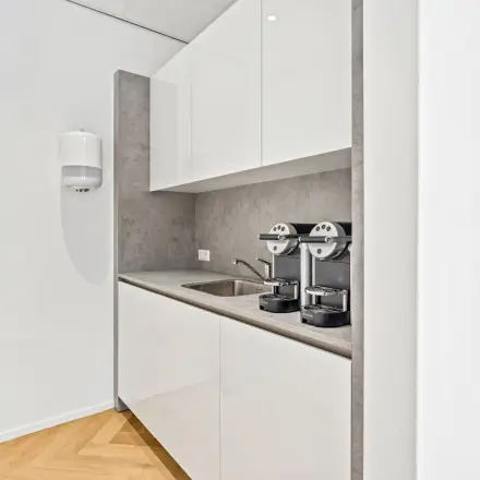 Compact kitchenette with a countertop, sink, and two coffee machines, ideal for break times in this office space rental at Maanlander 43, Amersfoort Calveen.
