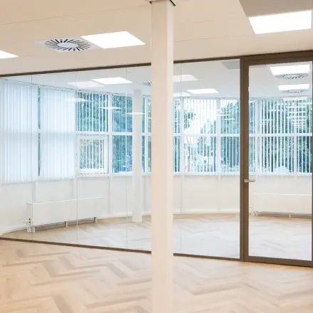 Empty office space at Maanlander 43, Amersfoort Calveen, featuring large windows and parquet flooring, ideal for office space rental.