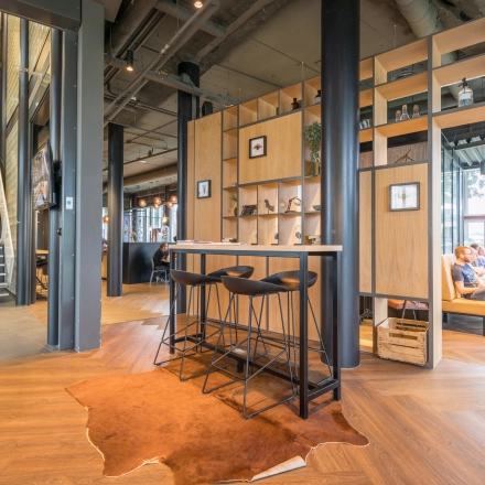 Stylish office space at Maanlander 47, Amersfoort Calveen, featuring modern furnishings and people collaborating at tables, ideal for office space rental.