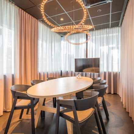 Bright office space rental at Maanlander 47, Amersfoort Calveen, featuring a well-lit conference room with stylish lighting and a flat-screen TV.