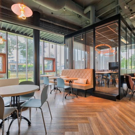 Modern furnished office space for rent at Maanlander 47 in Amersfoort Calveen, featuring elegant seating areas with large windows and contemporary lighting.