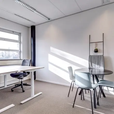 Bright office space for rent featuring desks, chairs, and a small meeting table at Maanlander 47, Amersfoort Calveen.