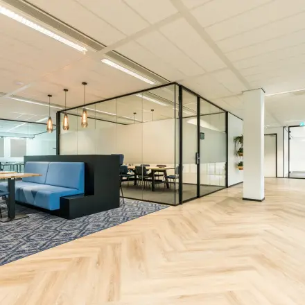 Modern office space at Spoetnik 10-64 in Amersfoort Calveen, featuring stylish furnishings and glass-partitioned meeting areas, available for office space rental.