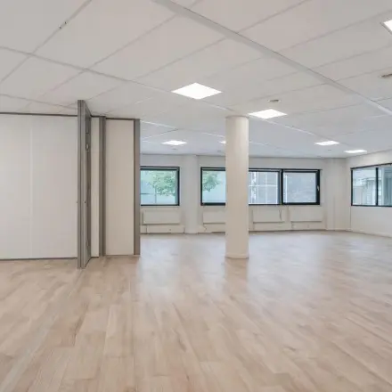 Spacious office to rent at Asch van Wijckstraat 2-4, Amersfoort Centrum, featuring large windows and a light wood floor, ideal for customizing your office space rental needs.