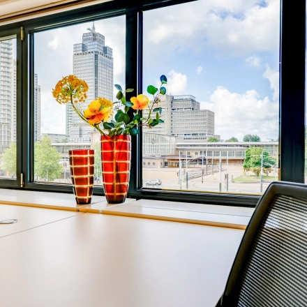 Bright office space at Prins Bernhardplein 200, Amsterdam Amstel, featuring a desk with chairs and a view of the cityscape.