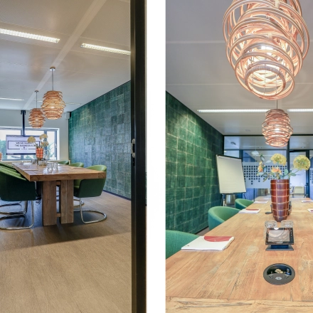 Inviting office space with a large wooden table, green chairs, and modern lighting at Prins Bernhardplein 200, Amsterdam Amstel, perfect for office space rental.