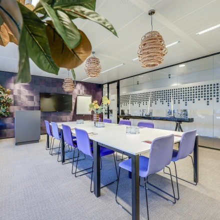 Modern furnished office space at Prins Bernhardplein 200, Amsterdam Amstel, featuring a conference room with a long table and seating for meetings. Ideal for office space rental.