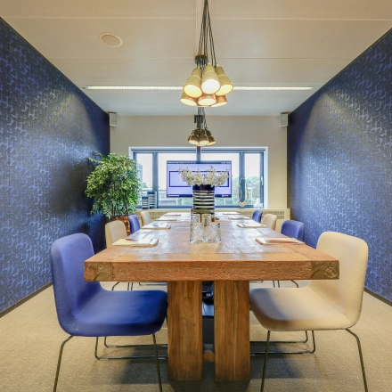 Modern conference room with wooden table and upholstered chairs, available for office space rental at Prins Bernhardplein 200, Amsterdam Amstel.