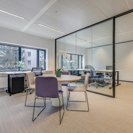 Modern office space at Prins Bernhardplein 200 in Amsterdam Amstel, featuring glass walls, desks, and seating. Ideal for office space rental with natural light.