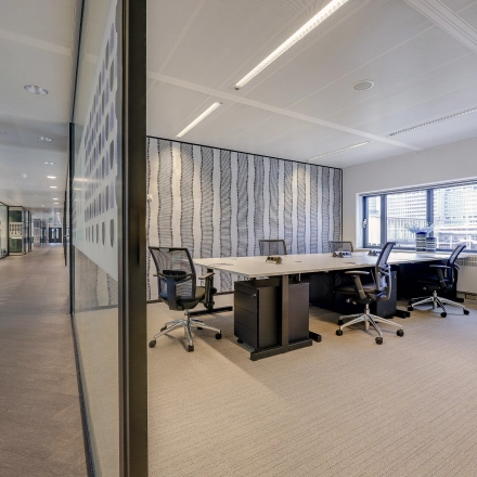 Modern office space with glass partitions at Prins Bernhardplein 200, Amsterdam Amstel, ideal for office space rental. Bright workspace with chairs and desks offering plenty of natural light.