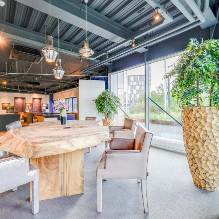 Modern furnished office space at Prins Bernhardplein 200, Amsterdam Amstel with unique wooden table and large windows. Perfect for office space rental.